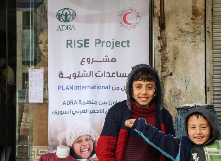 Children wearing winter clothing provided by the RISE project in Aleppo